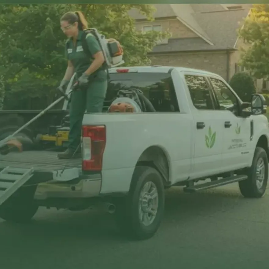 Summit Green crew unloading professional lawn equipment from a company truck