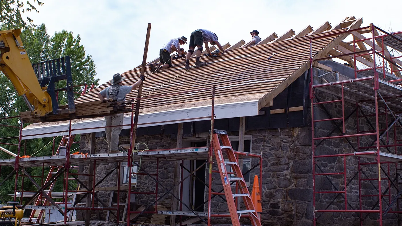Roofing crew installing a new roof deck on a residential building